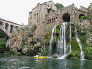 Kayaking by an ancient building and waterfall