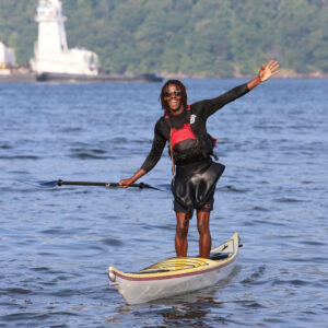 Chev Dixon stading on top of a kayak on the water